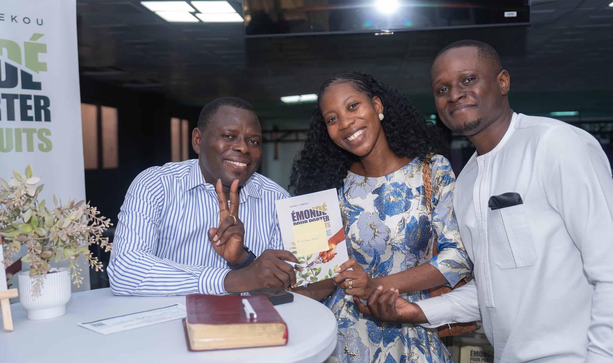 Séance de dédicace : Samuel Y. GBEKOU signe un exemplaire pour un couple.